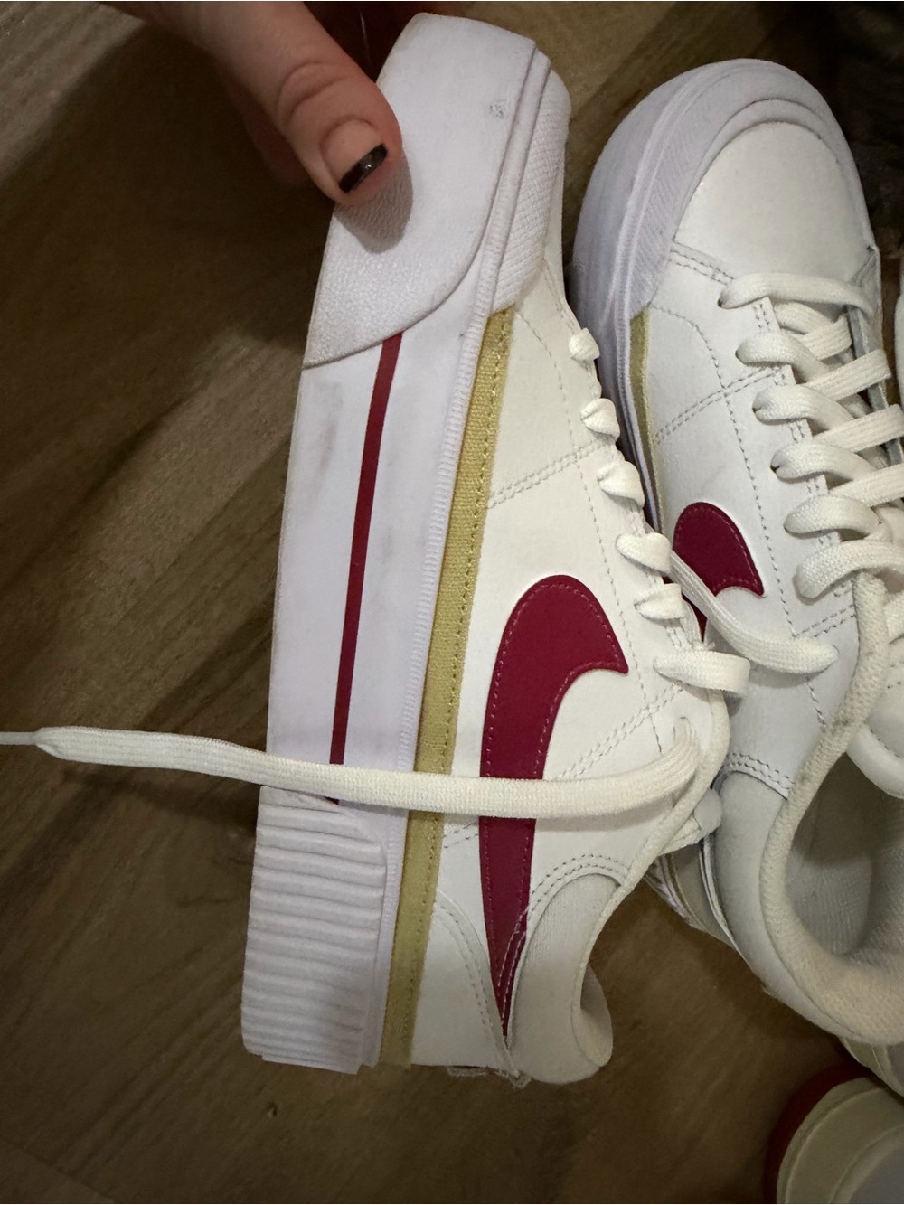 White Nike Sneakers with Red Swoosh and Gold Stripe